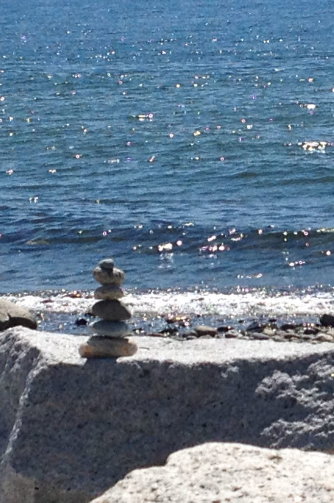 Photograph of an Inuksuk on a beach facing towards the Pacific ocean on contact Barbara Webb page